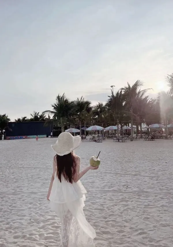 Khung hình ngược nắng có flare nhẹ, cô gái che mặt, đường tóc mềm và da sáng.